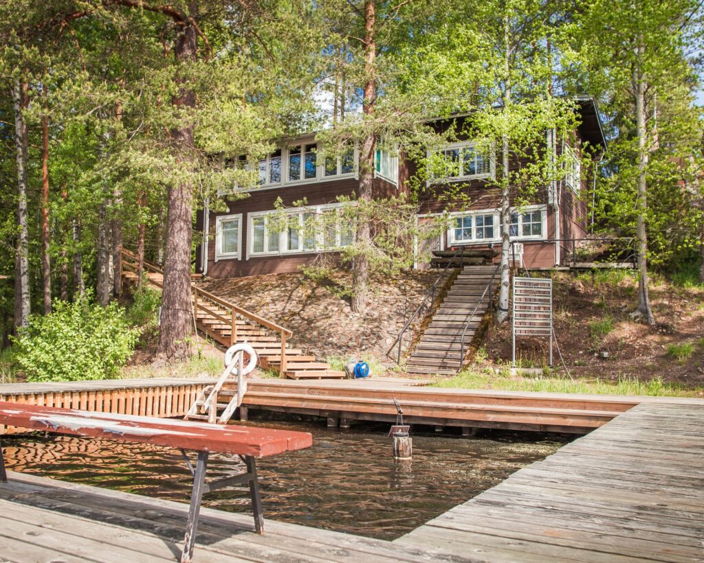 Ruskea vanha sauna lammen rannalla.