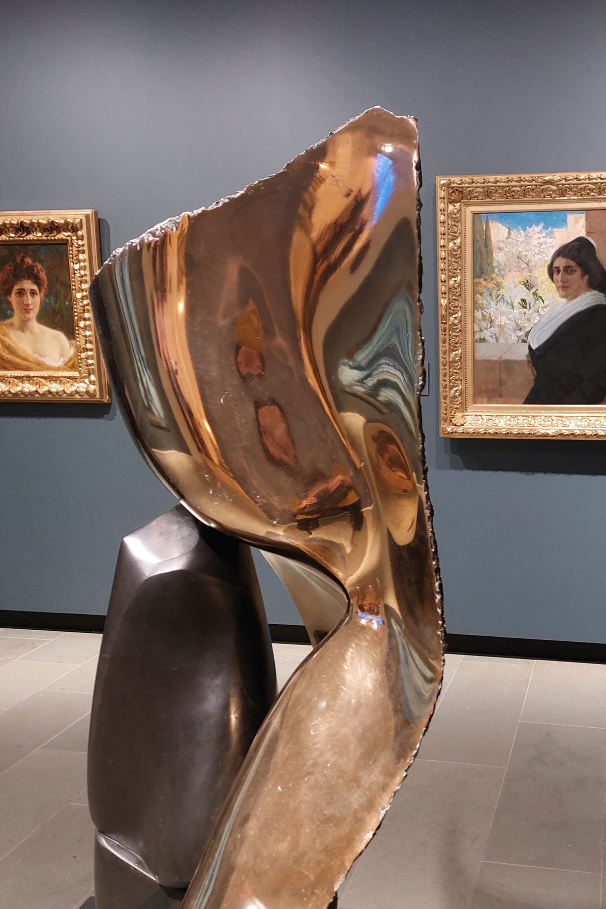 Pronssinen abstrakti veistos.